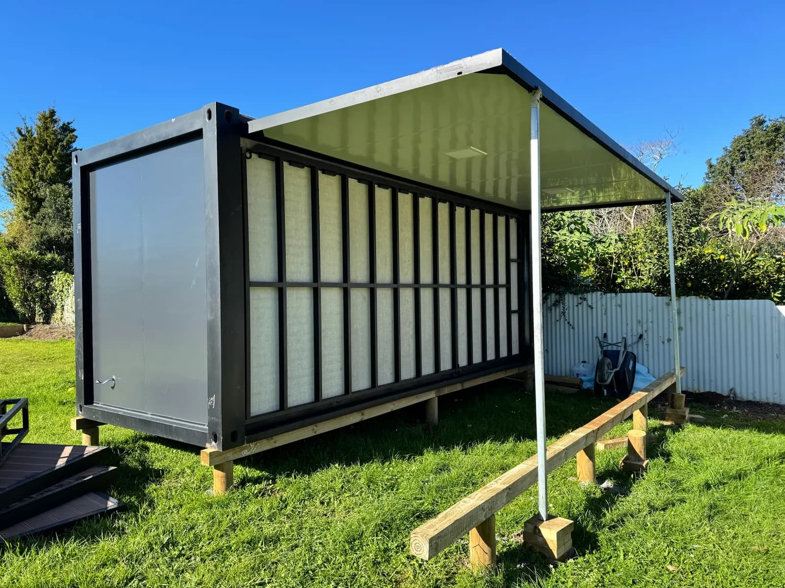 Studio on timber bearers with its roof wing raised, part-way through unfolding