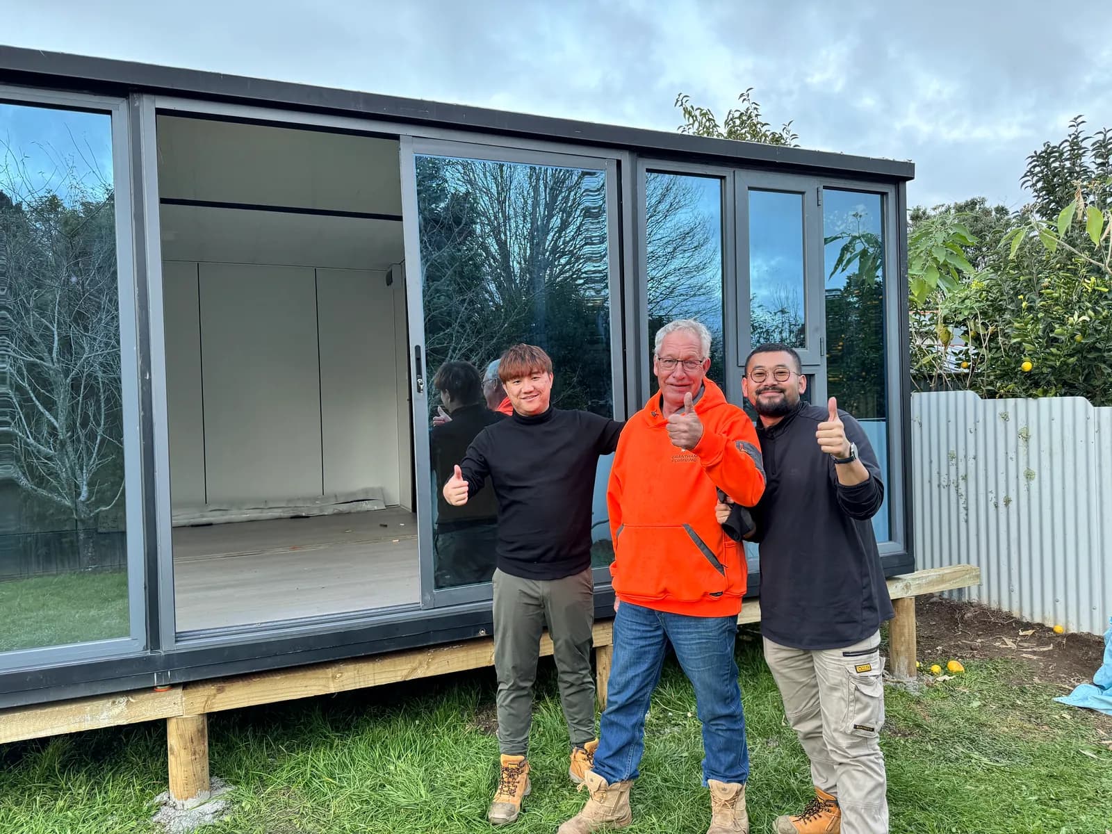 Rex and two others on site giving a thumbs up in front of a finished Studio on timber bearers