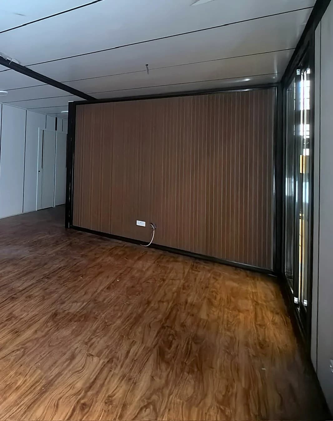 Walnut-look wall panelling meeting a matching timber-look floor