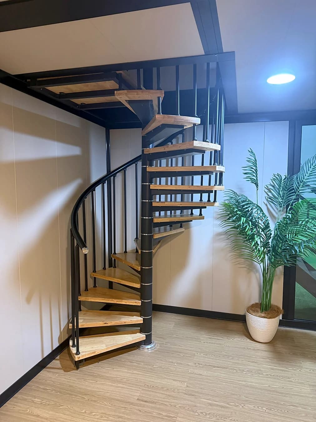 Spiral staircase with timber treads inside a two-storey unit