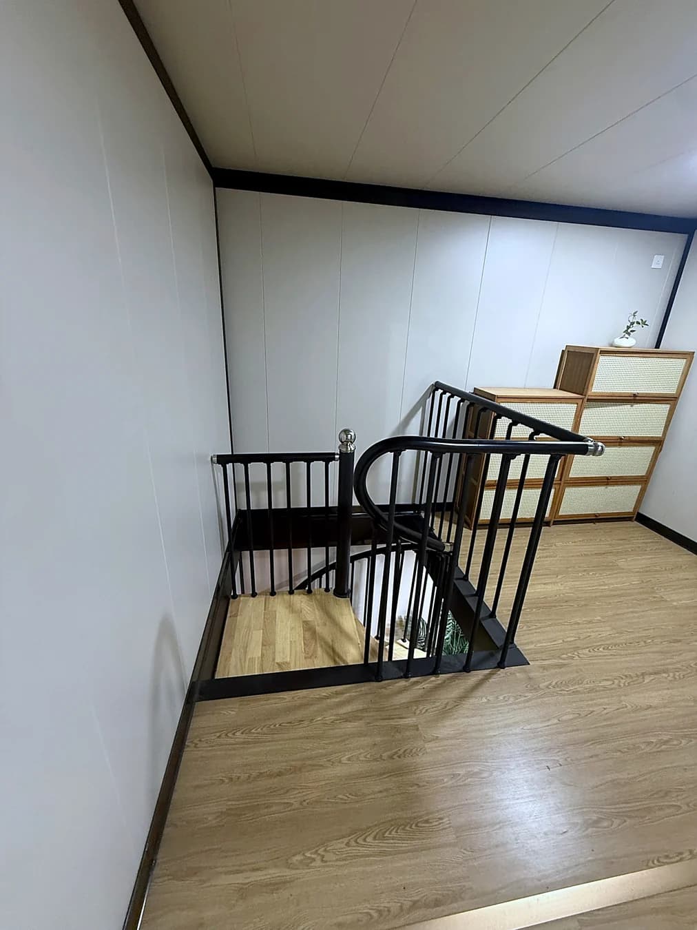 Upper-floor room with the stairwell opening and timber-look flooring