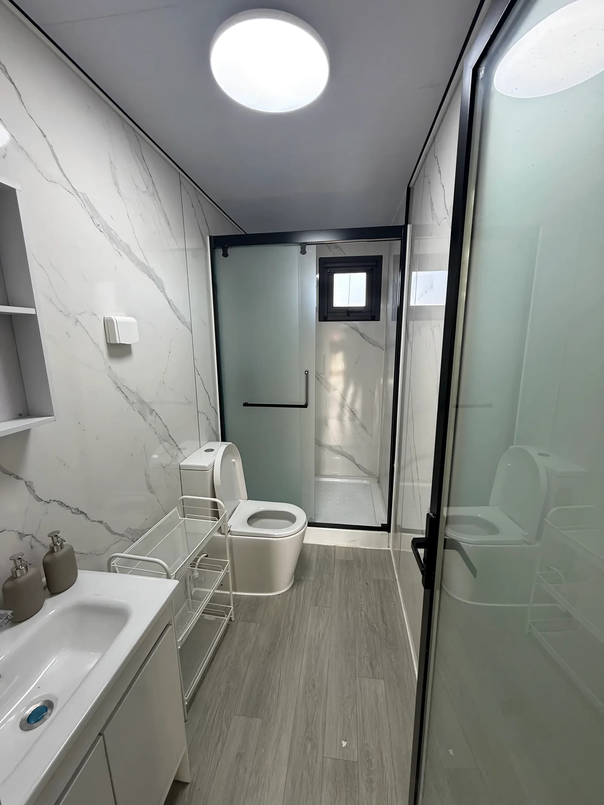 Finished bathroom with marble-look tiling inside an expandable home
