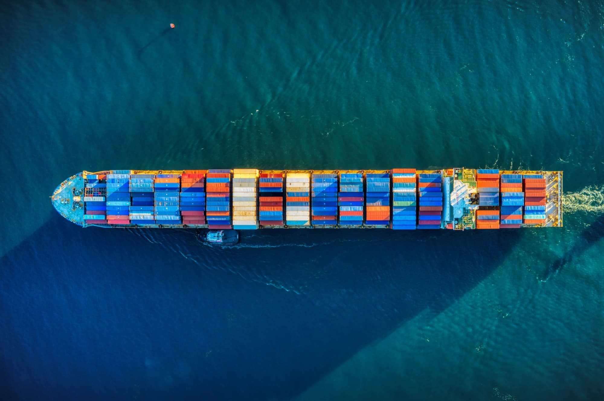 Aerial view of a container ship carrying cargo across open blue sea