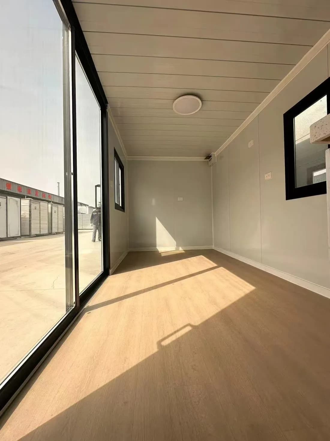 Inside a Ready 20 looking along the length of the room, with a ceiling light and a full-height glass door